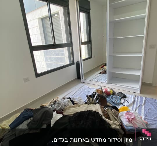 בגדים מפוזרים על הרצפה ליד ארון פתוח